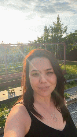 Woman documents afternoon garden activities with pet in Oktyabrsky