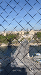 Tourist captures Paris cityscape from Eiffel Tower viewing area