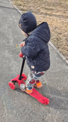Child rides red scooter in Tobolsk winter gear