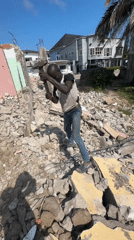 Building demolition underway in Badagry with heavy machinery and manual labor