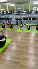 Group fitness class performs ab exercises in Izhevsk gym