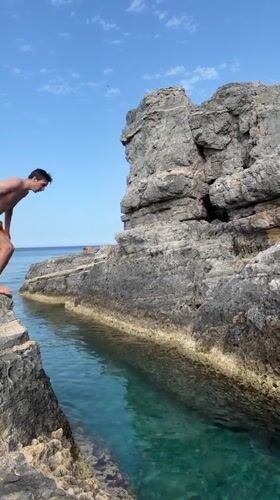 Swimmers and boaters enjoy clear waters near Lindos cliffs