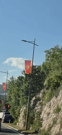 Montenegrin flags displayed along roadway in Cetinje