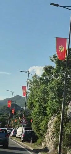 Montenegrin flags displayed along roadway in Cetinje