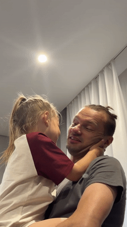 Father, daughter share quiet moment indoors in Chaikovsky