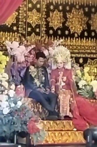 Formal wedding ceremony with ornate staging and traditional attire