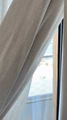 Marina view captured through window curtain in Sant Adrià