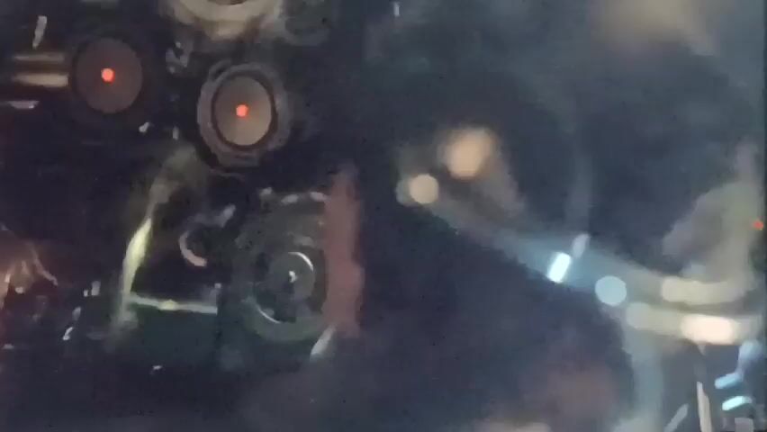 A short video clip shows a close-up of a person's terrified eyes. The person appears to be in a dimly lit environment. The clip also features a shot of mechanical objects with red glowing lights. In between these shots, a hand is seen manipulating some kind of device.