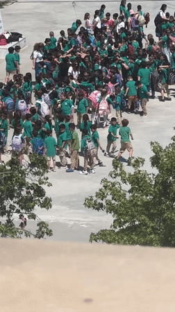 School children in green uniforms gather in Fethiye schoolyard