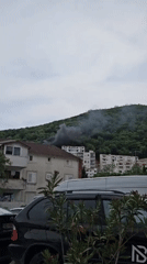 Smoke rises from building in residential neighborhood