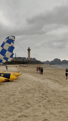 Morning parasailing activity observed at Vietnam beach under cloudy skies