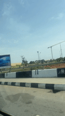 Vehicle drives through developing area of Abuja showing construction activity
