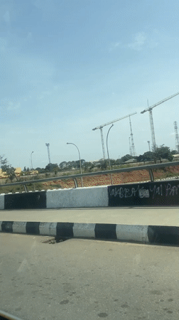 Vehicle drives through developing area of Abuja showing construction activity