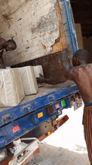 Workers unload wrapped packages from truck in Pasere, Nigeria
