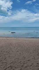 Early morning swimmers enjoy calm waters at Thai beach