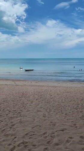 Early morning swimmers enjoy calm waters at Thai beach