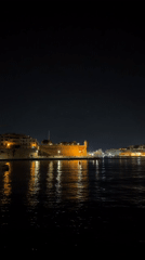 Valletta's illuminated fortifications and harbor yachts at night