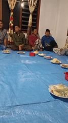 Communal meal on a blue tarp in Ketepung, Indonesia