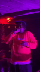 Performer takes stage at London club under colored lights