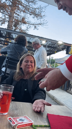 Magician entertains diners with card tricks at French restaurant