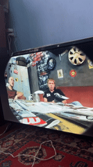 Garage meeting with TV footage of a safe being carried outdoors