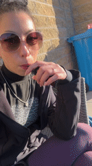 Woman vapes outdoors during sunny Liverpool afternoon
