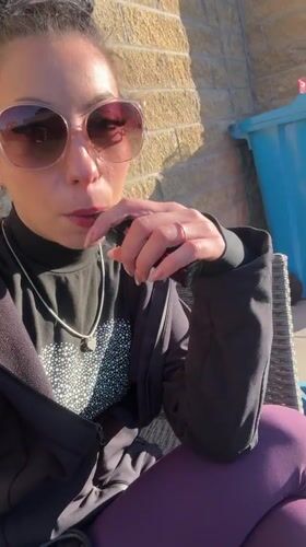 Woman vapes outdoors during sunny Liverpool afternoon