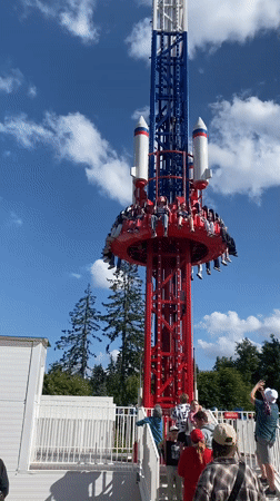 Sunny afternoon at Saint Petersburg amusement park with rides and crowds