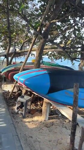 Colorful surfboard on a Bali beach, ready for the day.