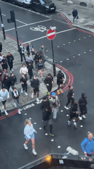 Group of 30 runners cross London street in athletic wear