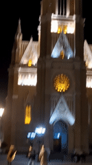 Street musician performs at illuminated Novi Sad church