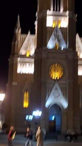 Street musician performs at illuminated Novi Sad church
