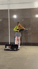 Street musician performs violin in Moscow subway station