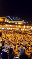 Nighttime street performance with costumed dancers on cobblestone