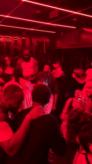 Late-night dancing and socializing at a red-lit Paris club