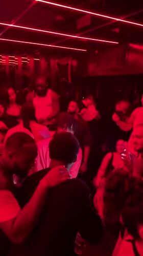 Late-night dancing and socializing at a red-lit Paris club