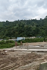 Road construction cuts through terraced valley hills in Thakre, Nepal