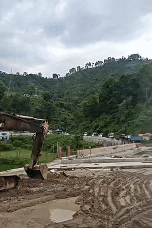 Road construction cuts through terraced valley hills in Thakre, Nepal