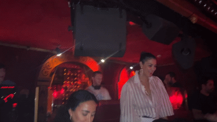 Woman dances on platform at Paris nightclub early morning