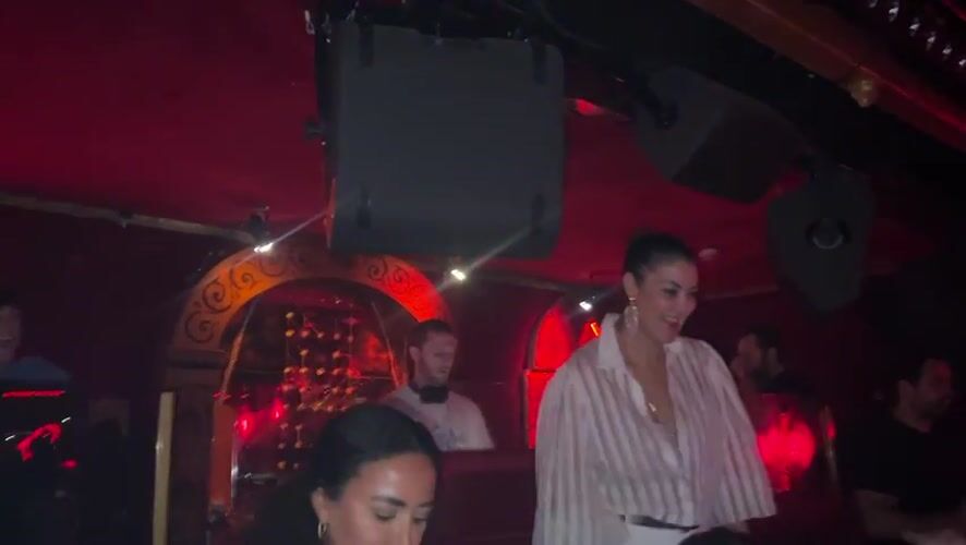 Woman dances on platform at Paris nightclub early morning