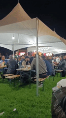 Evening outdoor event draws attendees to tented gathering