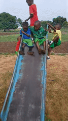 Children play on playground slide during morning hours