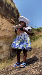 Girl reads book on rocky terrain in Amaseri, Nigeria