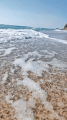 Sunny morning at the beach, waves rolling in from multiple angles