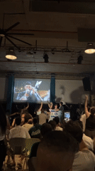 Tel Aviv crowd watches male performer on venue projection screen