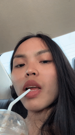 Woman drinks from cup in car, Davao City