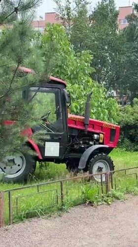 Tractor mows park grass alongside blooming roses in Saint Petersburg