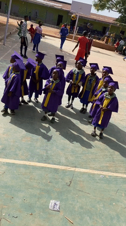 Children celebrate graduation ceremony on basketball court in Nigeria