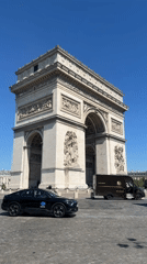 Normal traffic flows around Arc de Triomphe on sunny Friday