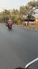 Motorcycle traffic moving through suburban Gelam streets